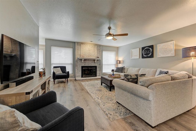 8517 SW 36th Ter, Oklahoma City, OK 73179 - living area with a fireplace, a ceiling fan, wood finished floors, and a textured ceiling