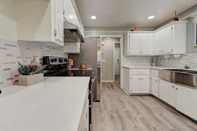 8517 SW 36th Ter, Oklahoma City, OK 73179 - kitchen featuring under cabinet range hood, white cabinets, tasteful backsplash, and recessed lighting