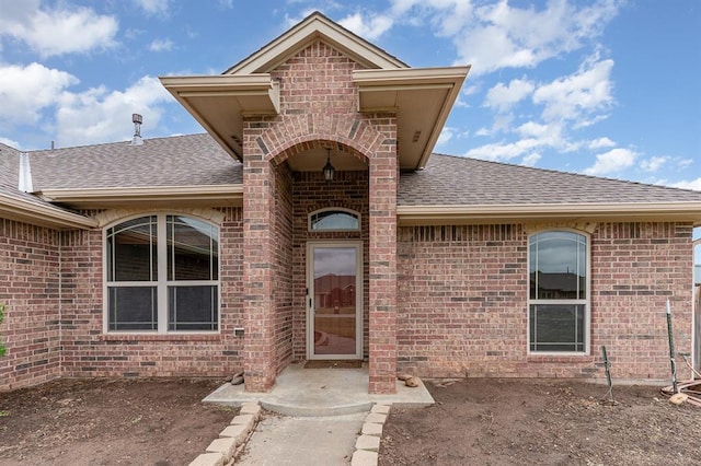 2524 Faint Ridge Way, Piedmont, OK 73078 - property entrance with roof with shingles, brick siding, and a patio
