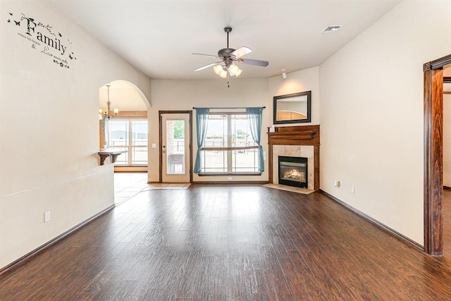 2524 Faint Ridge Way, Piedmont, OK 73078 - unfurnished living room with ceiling fan, arched walkways, a fireplace, wood finished floors, and a chandelier