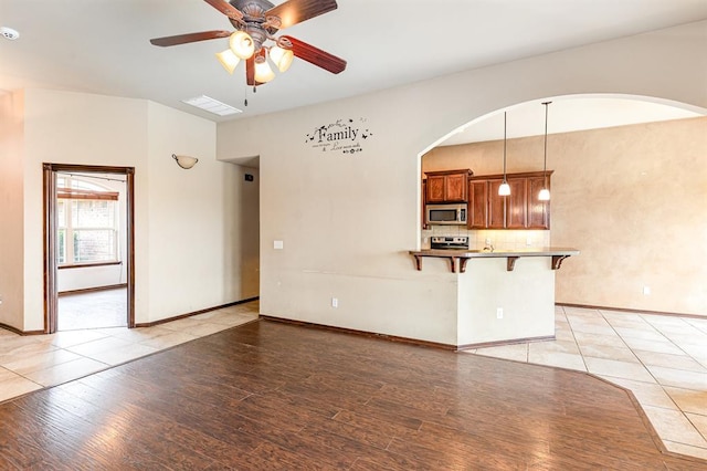 2524 Faint Ridge Way, Piedmont, OK 73078 - unfurnished living room with ceiling fan, light wood-type flooring, and arched walkways