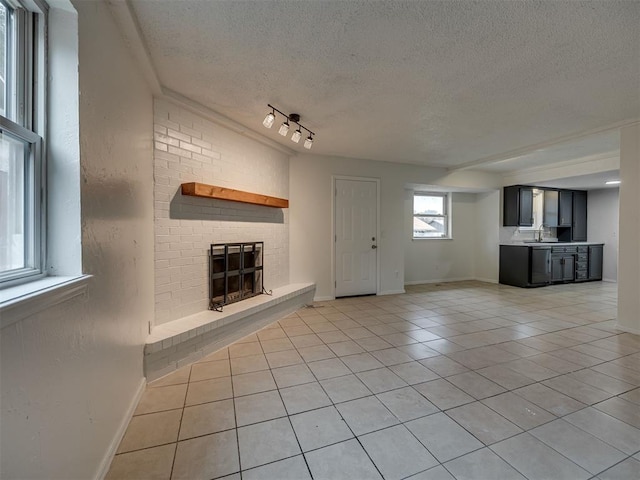 4821 Cinderella Dr, Oklahoma City, OK 73129 - unfurnished living room featuring light tile patterned floors, a fireplace, and a textured ceiling