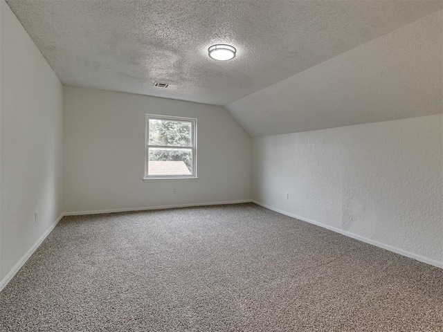 4821 Cinderella Dr, Oklahoma City, OK 73129 - additional living space featuring a textured ceiling, carpet flooring, and lofted ceiling