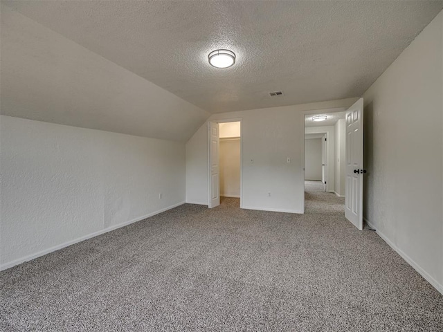 4821 Cinderella Dr, Oklahoma City, OK 73129 - additional living space with a textured ceiling, carpet flooring, and vaulted ceiling