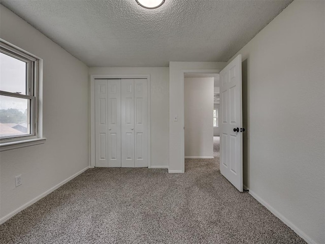 4821 Cinderella Dr, Oklahoma City, OK 73129 - unfurnished bedroom featuring a textured ceiling, multiple windows, carpet floors, and a closet