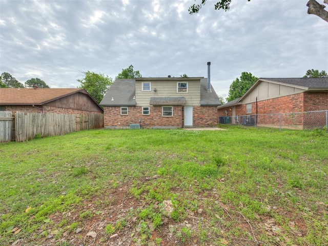 4821 Cinderella Dr, Oklahoma City, OK 73129 - rear view of house with brick siding and a fenced backyard