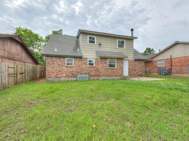 4821 Cinderella Dr, Oklahoma City, OK 73129 - back of house featuring a fenced backyard, brick siding, roof with shingles, and a patio
