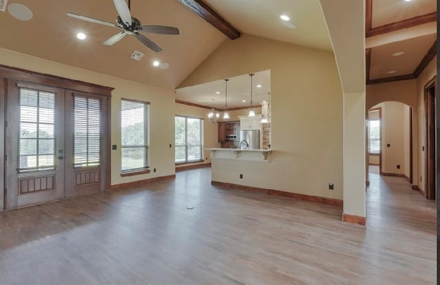30202 Sleepy Hollow Dr, Mcloud, OK 74851 - unfurnished living room featuring beam ceiling, light wood-style floors, french doors, arched walkways, and ceiling fan