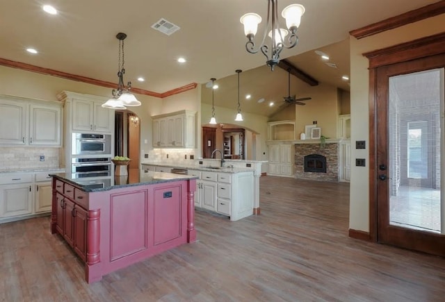 30202 Sleepy Hollow Dr, Mcloud, OK 74851 - kitchen with appliances with stainless steel finishes, backsplash, a peninsula, a fireplace, and recessed lighting