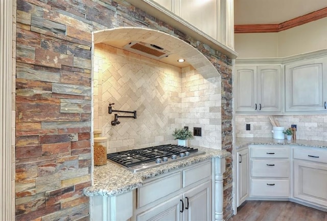 30202 Sleepy Hollow Dr, Mcloud, OK 74851 - kitchen featuring stainless steel gas cooktop, backsplash, light stone countertops, crown molding, and white cabinetry