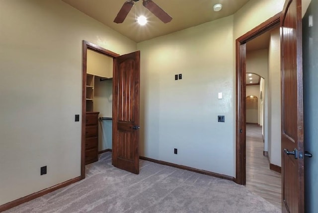 30202 Sleepy Hollow Dr, Mcloud, OK 74851 - unfurnished bedroom featuring arched walkways, light carpet, a spacious closet, a ceiling fan, and a closet