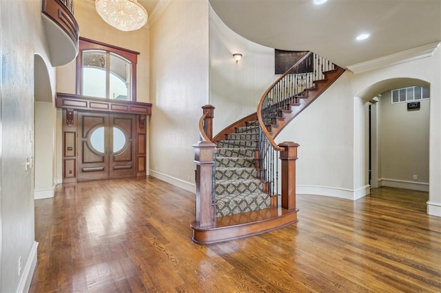 13209 Blue Canyon Cir, Oklahoma City, OK 73142 - entrance foyer with arched walkways, wood finished floors, stairway, a towering ceiling, and crown molding