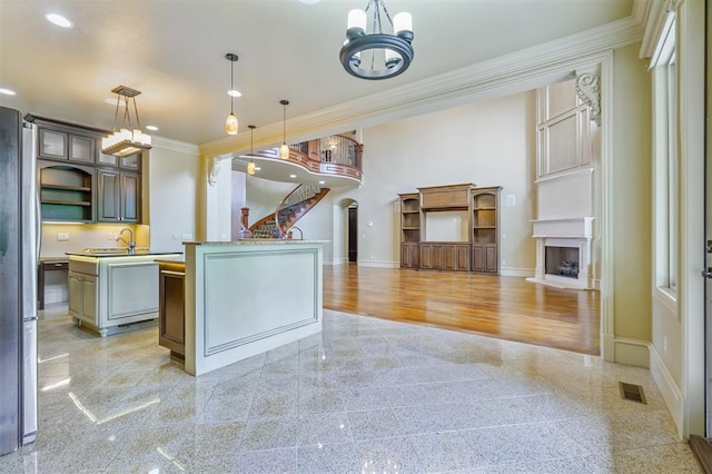 13209 Blue Canyon Cir, Oklahoma City, OK 73142 - kitchen with crown molding, an island with sink, granite tiled floors, a chandelier, and arched walkways