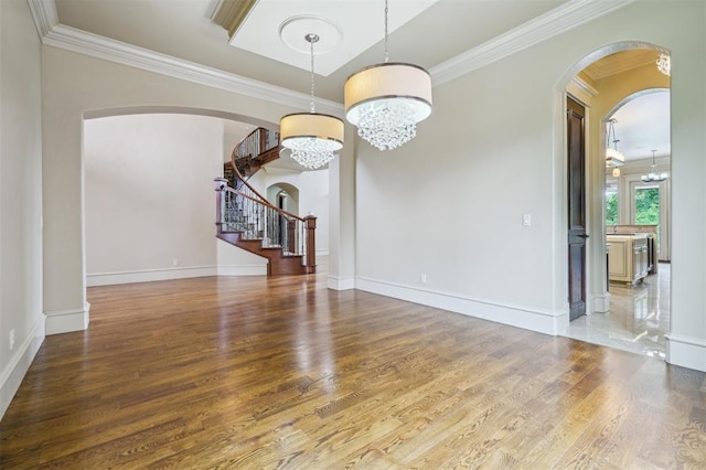 13209 Blue Canyon Cir, Oklahoma City, OK 73142 - unfurnished room with arched walkways, wood finished floors, ornamental molding, and a chandelier