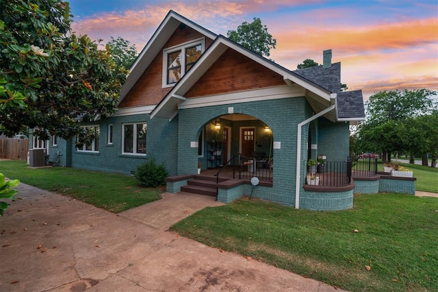 1828 S 7th St, Chickasha, OK 73018 - craftsman-style home with a porch, brick siding, a chimney, and a yard