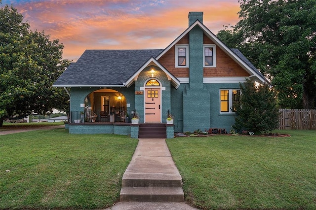 1828 S 7th St, Chickasha, OK 73018 - view of front facade with covered porch, a chimney, brick siding, and a shingled roof