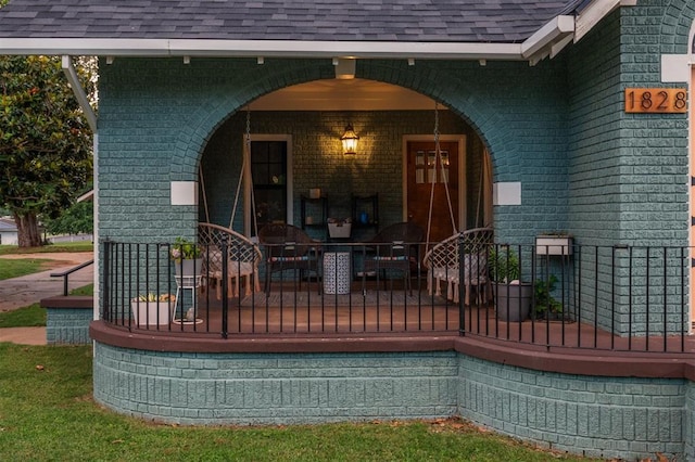 1828 S 7th St, Chickasha, OK 73018 - property entrance with covered porch, roof with shingles, and brick siding