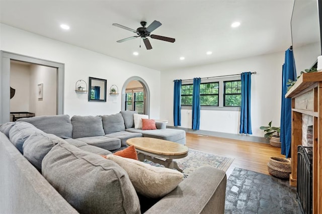 1828 S 7th St, Chickasha, OK 73018 - living room featuring recessed lighting, a fireplace, ceiling fan, arched walkways, and wood finished floors