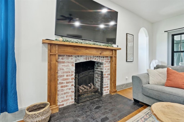 1828 S 7th St, Chickasha, OK 73018 - living room with arched walkways, wood finished floors, and a brick fireplace