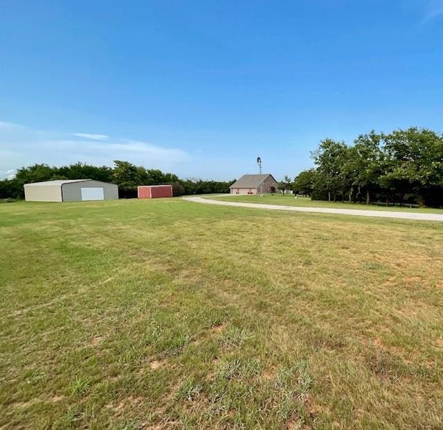 13501 E Memorial Rd, Jones, OK 73049 - view of green lawn featuring an outdoor structure and a garage