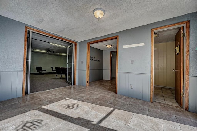 1028 N 11th St, Chickasha, OK 73018 - hall with a textured ceiling, wainscoting, and a textured wall