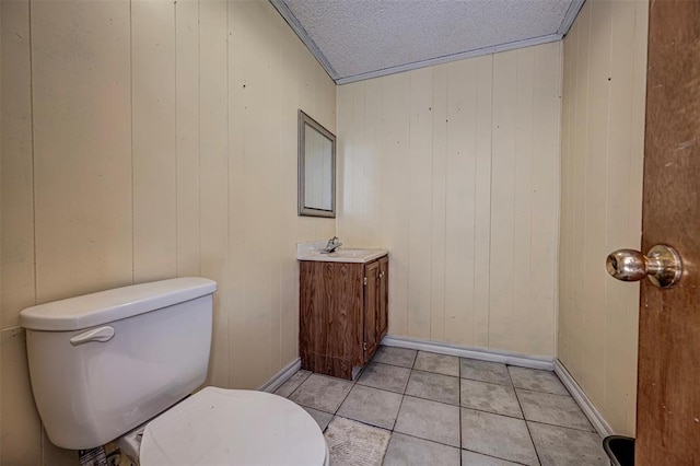 1028 N 11th St, Chickasha, OK 73018 - half bath with vanity, tile patterned flooring, a textured ceiling, and wood walls