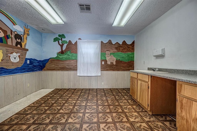 1028 N 11th St, Chickasha, OK 73018 - interior space with wood walls, a textured ceiling, and wainscoting