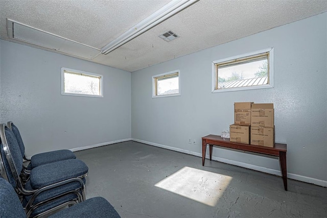1028 N 11th St, Chickasha, OK 73018 - unfurnished room with unfinished concrete flooring, a textured ceiling, and attic access