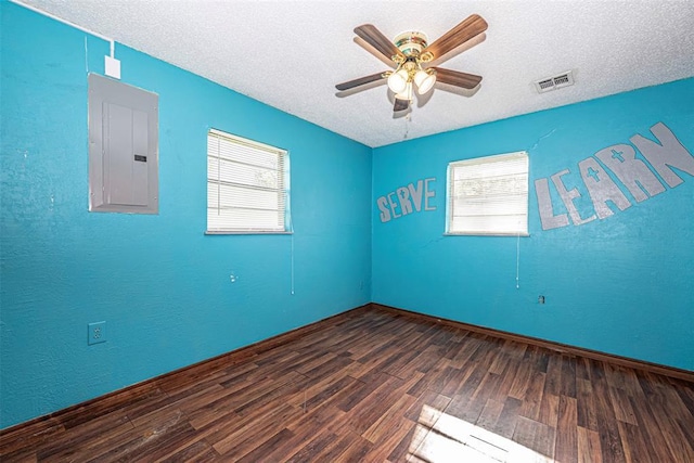 1028 N 11th St, Chickasha, OK 73018 - spare room featuring electric panel, wood finished floors, healthy amount of natural light, a textured ceiling, and a ceiling fan