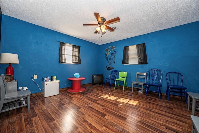 1028 N 11th St, Chickasha, OK 73018 - sitting room featuring a ceiling fan, a textured ceiling, and wood finished floors