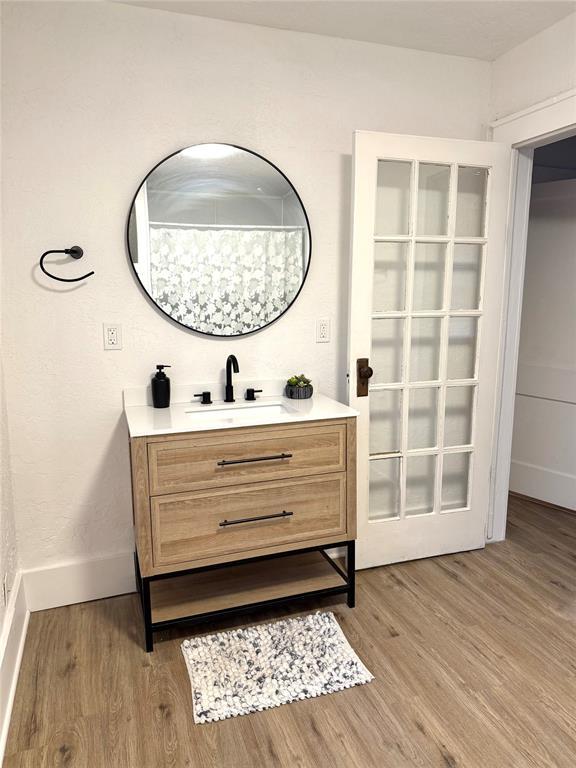 1402 S 14th St, Chickasha, OK 73018 - bathroom featuring vanity and wood finished floors