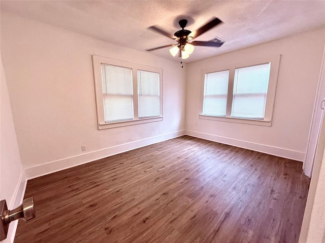 1402 S 14th St, Chickasha, OK 73018 - empty room featuring dark wood-type flooring, a ceiling fan, and a textured ceiling