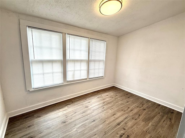 1402 S 14th St, Chickasha, OK 73018 - empty room with dark wood-style floors and a textured ceiling