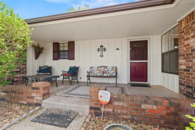 1912 Magnolia Ln, Edmond, OK 73013 - view of exterior entry with board and batten siding and a porch