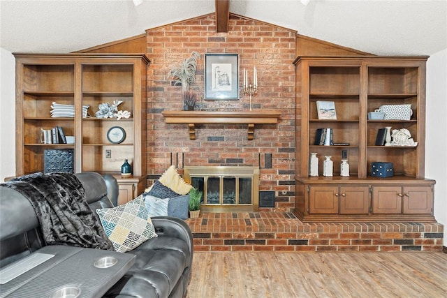 1912 Magnolia Ln, Edmond, OK 73013 - living room with lofted ceiling, wood finished floors, a fireplace, and a textured ceiling