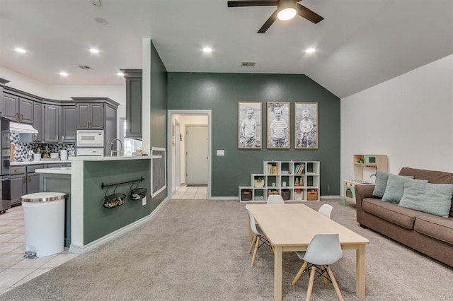 613 N Remington Way, Mustang, OK 73064 - living room featuring a ceiling fan, light carpet, light tile patterned floors, and lofted ceiling