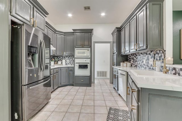 613 N Remington Way, Mustang, OK 73064 - kitchen with white appliances, gray cabinets, tasteful backsplash, light countertops, and recessed lighting