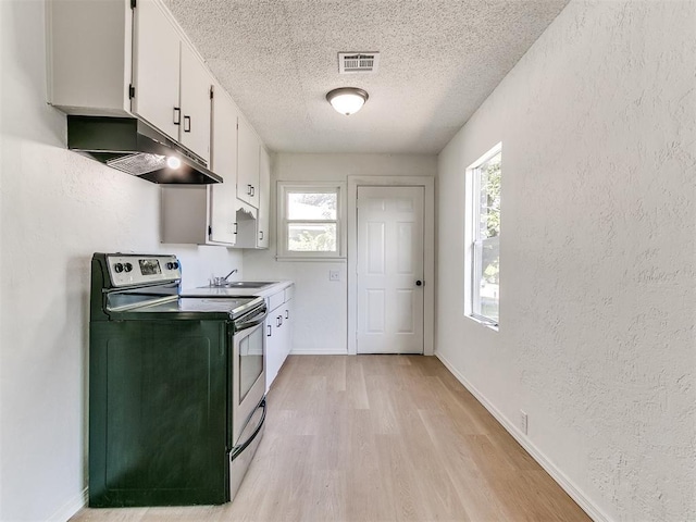 2924 SW 51st St, Oklahoma City, OK 73119 - kitchen featuring electric stove, under cabinet range hood, a textured ceiling, white cabinets, and light wood-type flooring