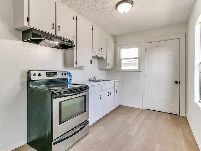 2924 SW 51st St, Oklahoma City, OK 73119 - kitchen with stainless steel electric stove, under cabinet range hood, a textured ceiling, white cabinets, and light wood-type flooring