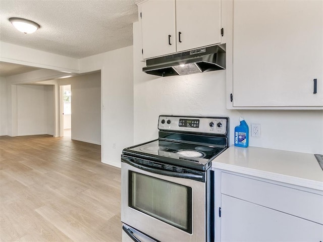 2924 SW 51st St, Oklahoma City, OK 73119 - kitchen with stainless steel range with electric stovetop, under cabinet range hood, light countertops, light wood-style flooring, and a textured ceiling