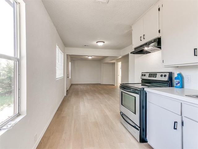 2924 SW 51st St, Oklahoma City, OK 73119 - kitchen with stainless steel range with electric cooktop, under cabinet range hood, a textured ceiling, light wood finished floors, and white cabinetry