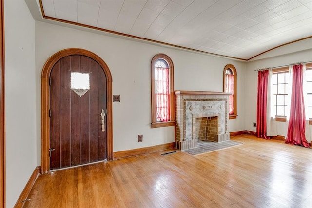 2705 NW 21st St, Oklahoma City, OK 73107 - foyer entrance with crown molding, arched walkways, wood finished floors, healthy amount of natural light, and a fireplace with flush hearth