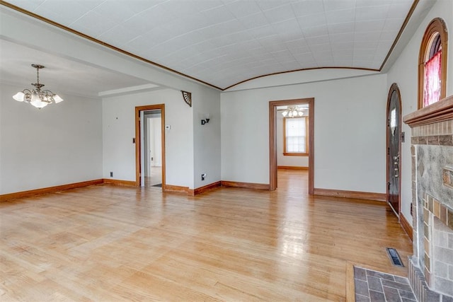 2705 NW 21st St, Oklahoma City, OK 73107 - unfurnished living room with a chandelier, a fireplace with flush hearth, and light wood-style flooring