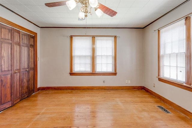 2705 NW 21st St, Oklahoma City, OK 73107 - unfurnished bedroom with light wood finished floors, ornamental molding, a closet, and ceiling fan