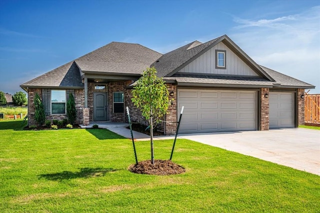 2001 W Crossbow Way, Mustang, OK 73065 - view of front of home featuring driveway, an attached garage, a front lawn, and brick siding