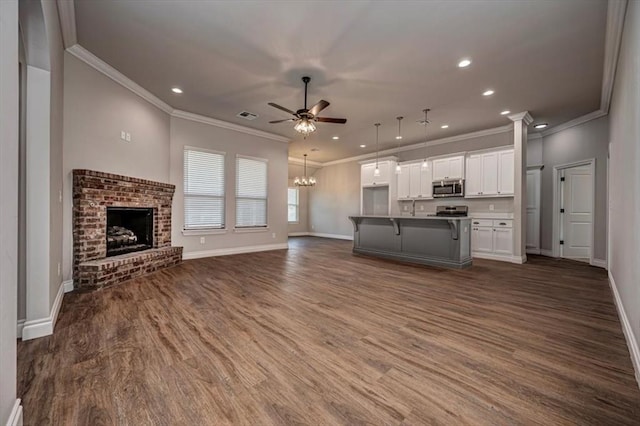2001 W Crossbow Way, Mustang, OK 73065 - unfurnished living room featuring crown molding, ceiling fan, recessed lighting, dark wood-style flooring, and a brick fireplace