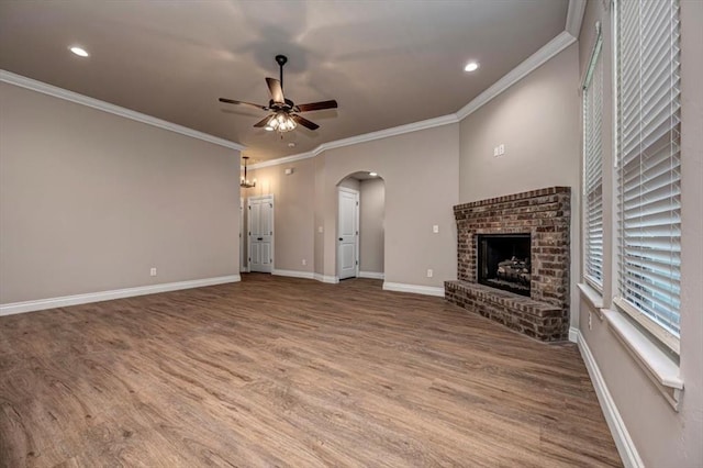 2001 W Crossbow Way, Mustang, OK 73065 - unfurnished living room featuring a ceiling fan, arched walkways, wood finished floors, a brick fireplace, and recessed lighting