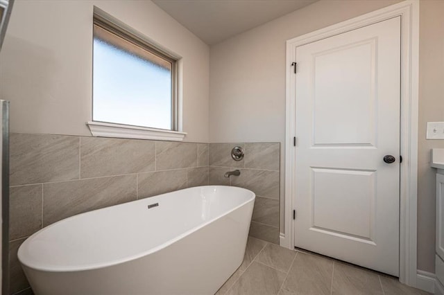 2001 W Crossbow Way, Mustang, OK 73065 - bathroom with a soaking tub, tile walls, tile patterned flooring, and vanity