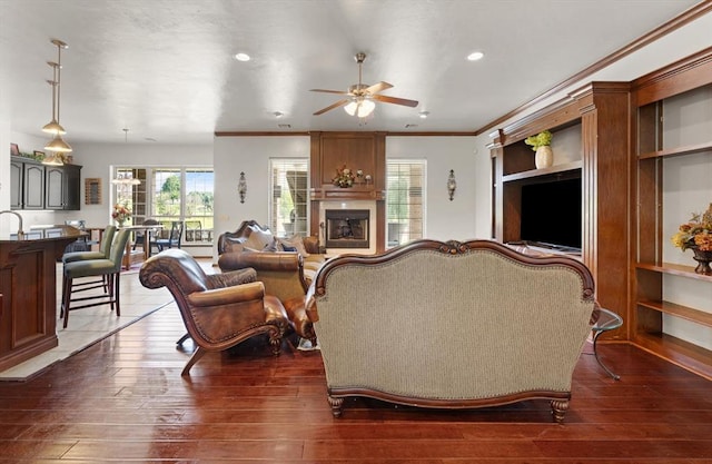 5420 NE 56th St, Oklahoma City, OK 73121 - living room featuring ceiling fan, plenty of natural light, crown molding, a large fireplace, and dark wood-style floors