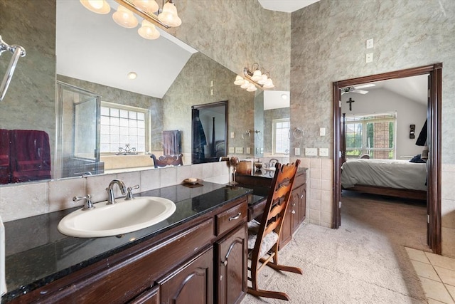 5420 NE 56th St, Oklahoma City, OK 73121 - bathroom with vaulted ceiling, vanity, connected bathroom, tile walls, and a chandelier
